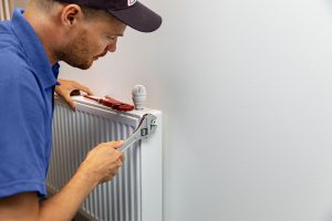 Technician fixing a home's radiator.