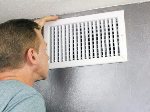 man examining air duct